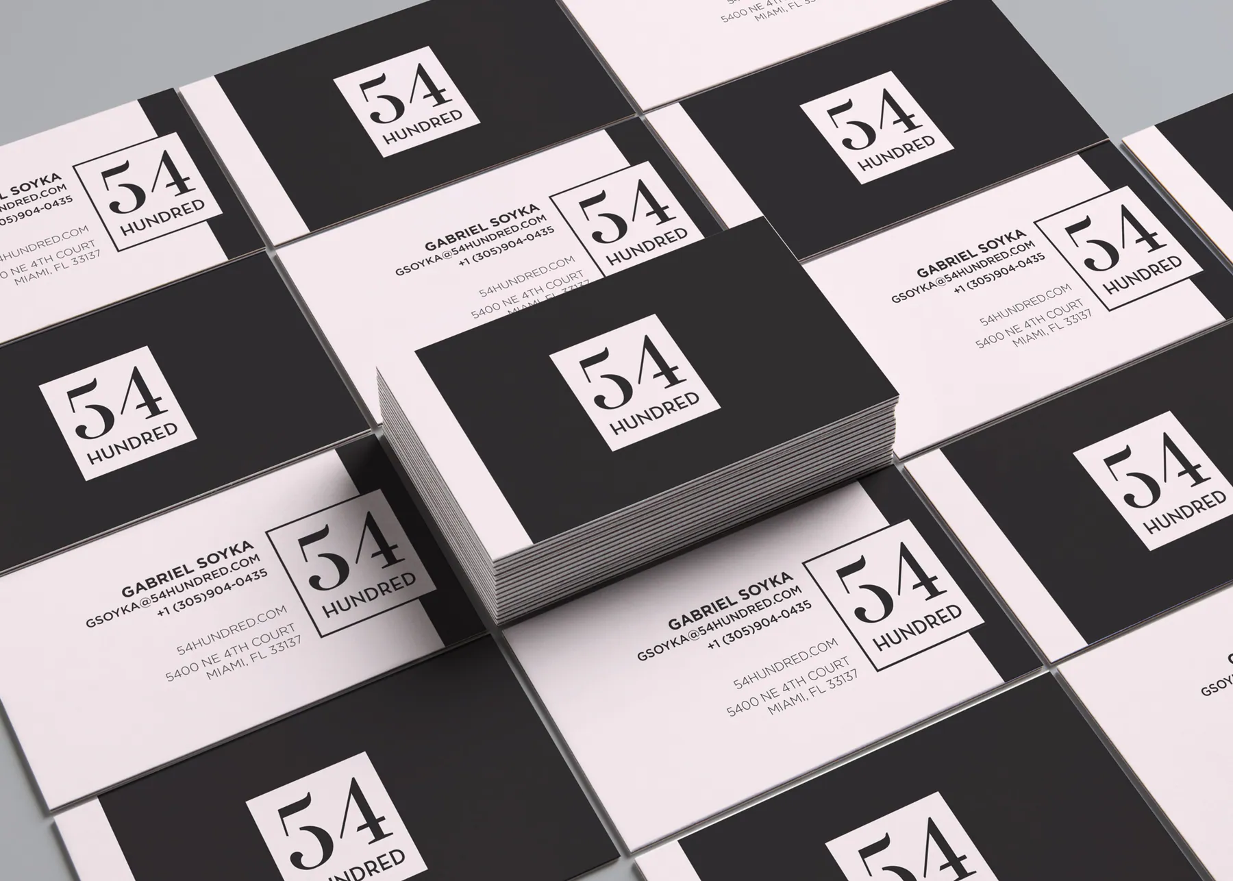 Mockup of black and pale blush 54 Hundred business cards arranged in a grid